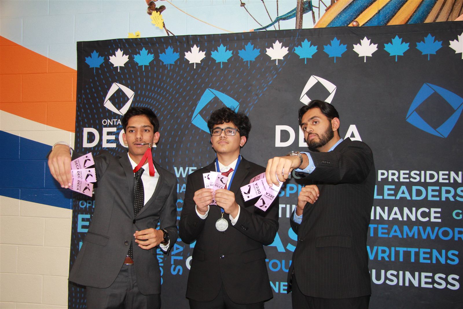Turner Fenton DECA members holding medals and ribbons at a competition