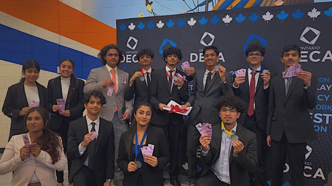 A group of Turner Fenton DECA members with medals backstage